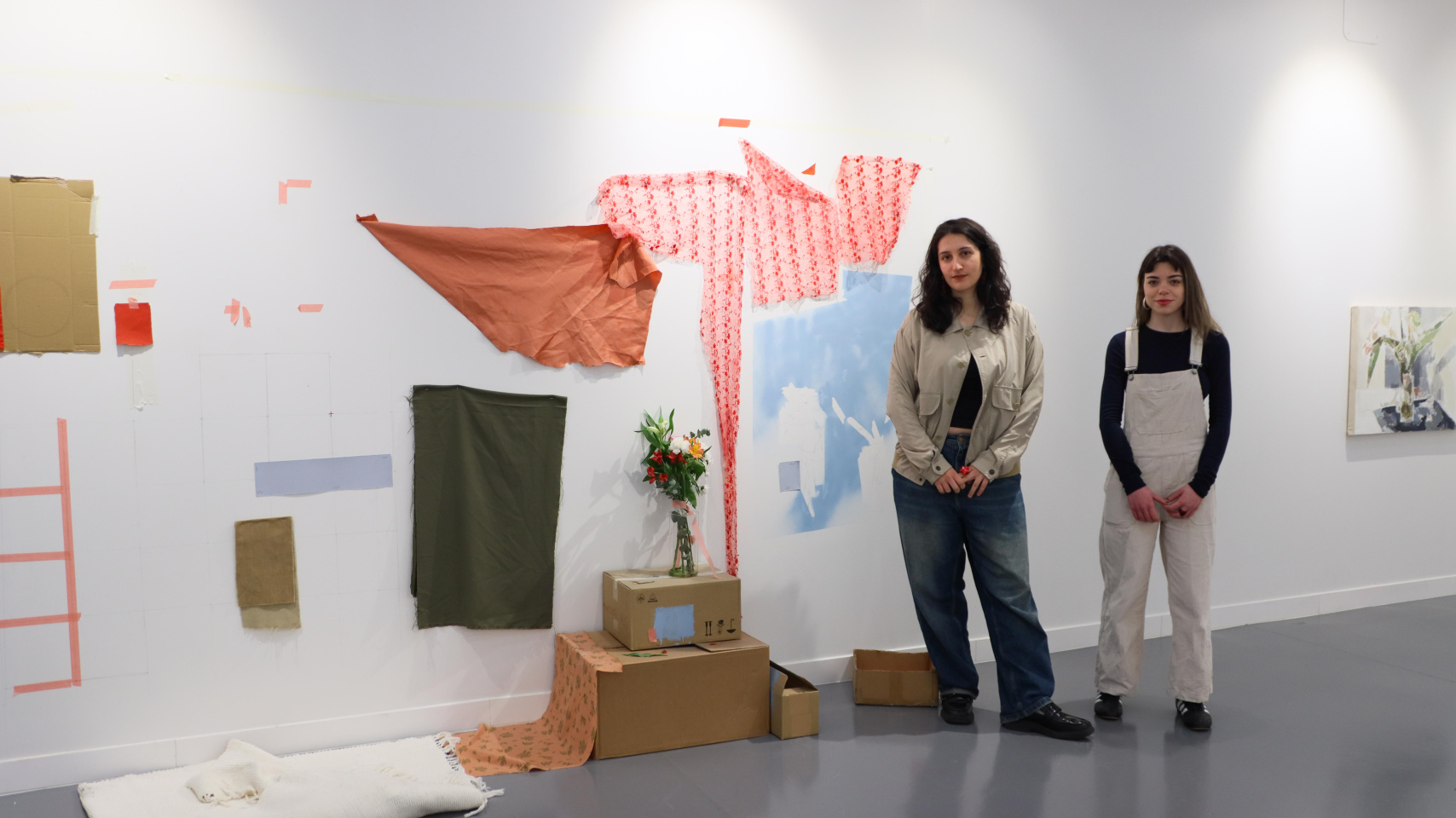 Las artistas Clara Herrero y Ruth Jiménez posan junto a una de sus obras recogidas en la exposición 'El desván'