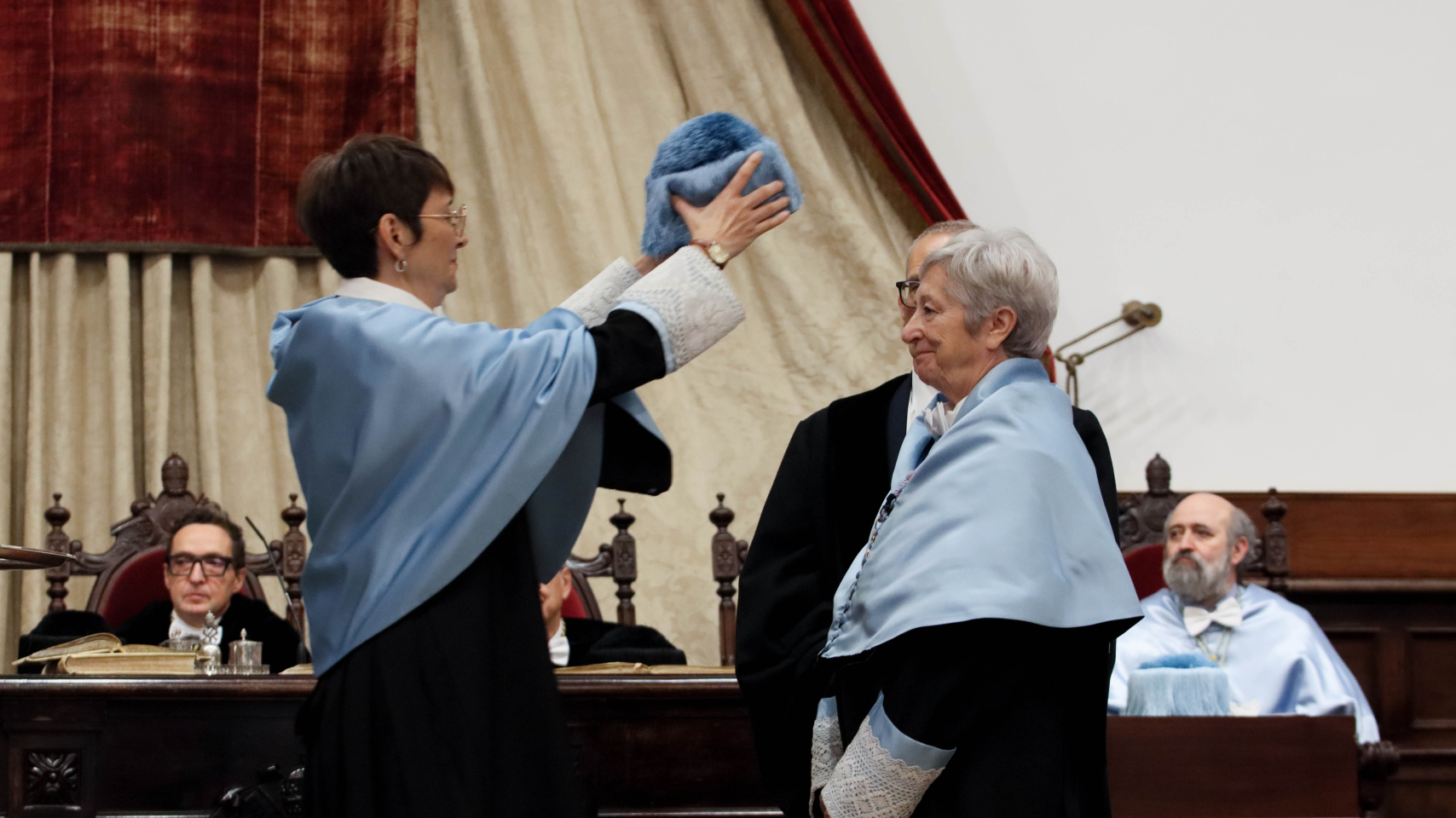 La madrina de Eulalia Pérez coloca el birrete sobre ella.