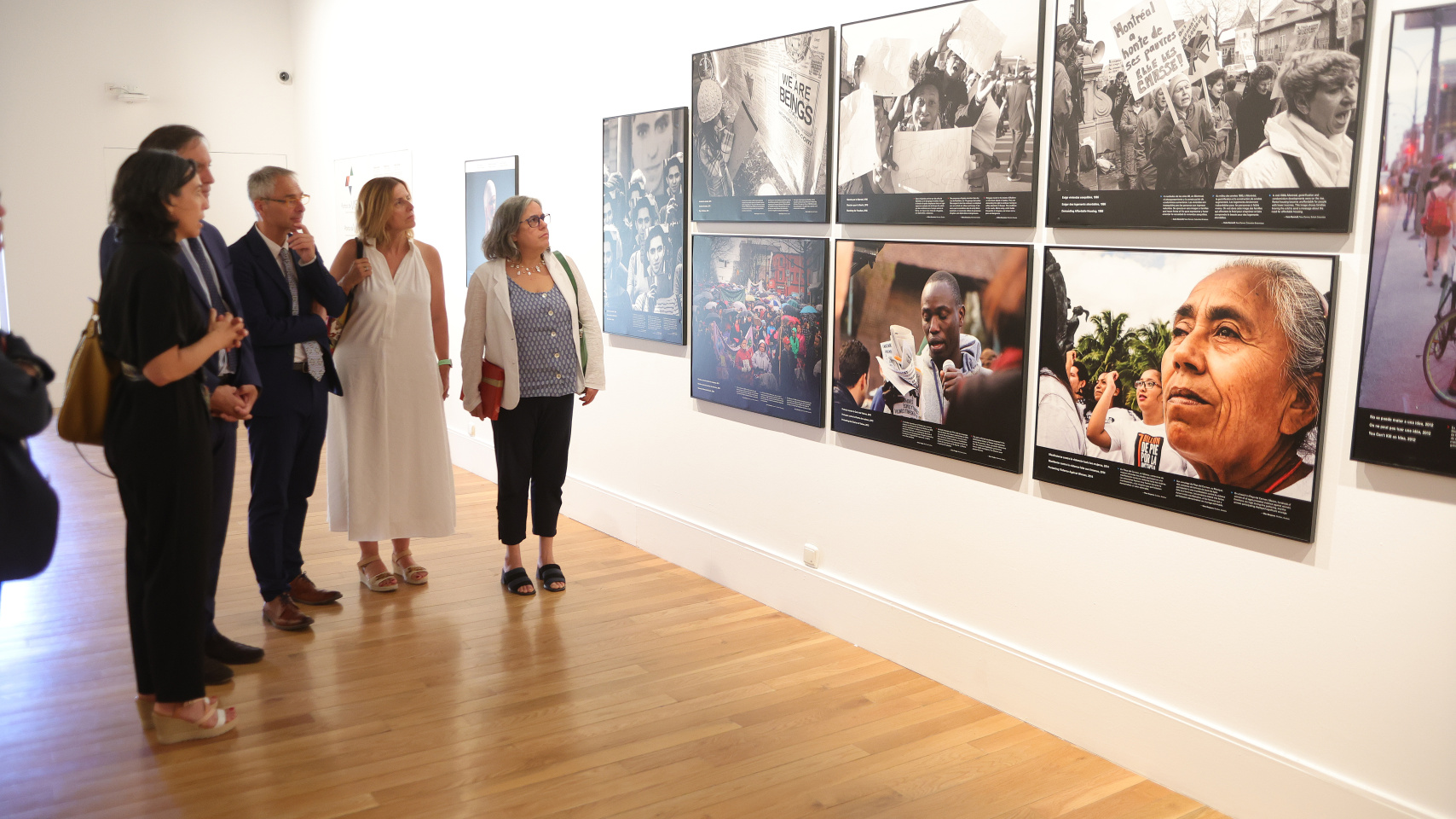 La embajadora explica alguna de las fotografías expuestas al resto de autoridades