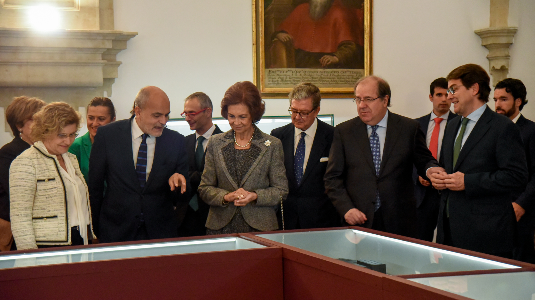 La comitiva que acompañó a la Reina durante su visita a la exposición observa las encuadernaciones procedentes de la Real Biblioteca
