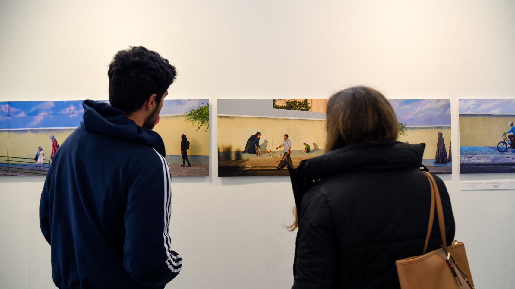 Dos alumnos observan las fotografías expuestas en la Facultad de Geografía e Historia de la USAL con motivo de la exposición 'Transversalidades. Fotografía sin fronteras’