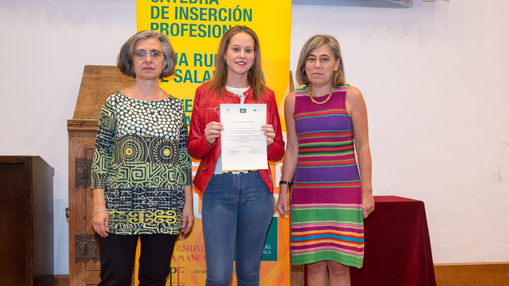 De izquierda a derecha: La vicerrectora de Atención al Estudiante y Extensión Universitaria, Cristina Pita; Paula Santos, estudiante beneficiaria del premio, y la directora general de Caja Rural de Salamanca, Isabel Martín Arija