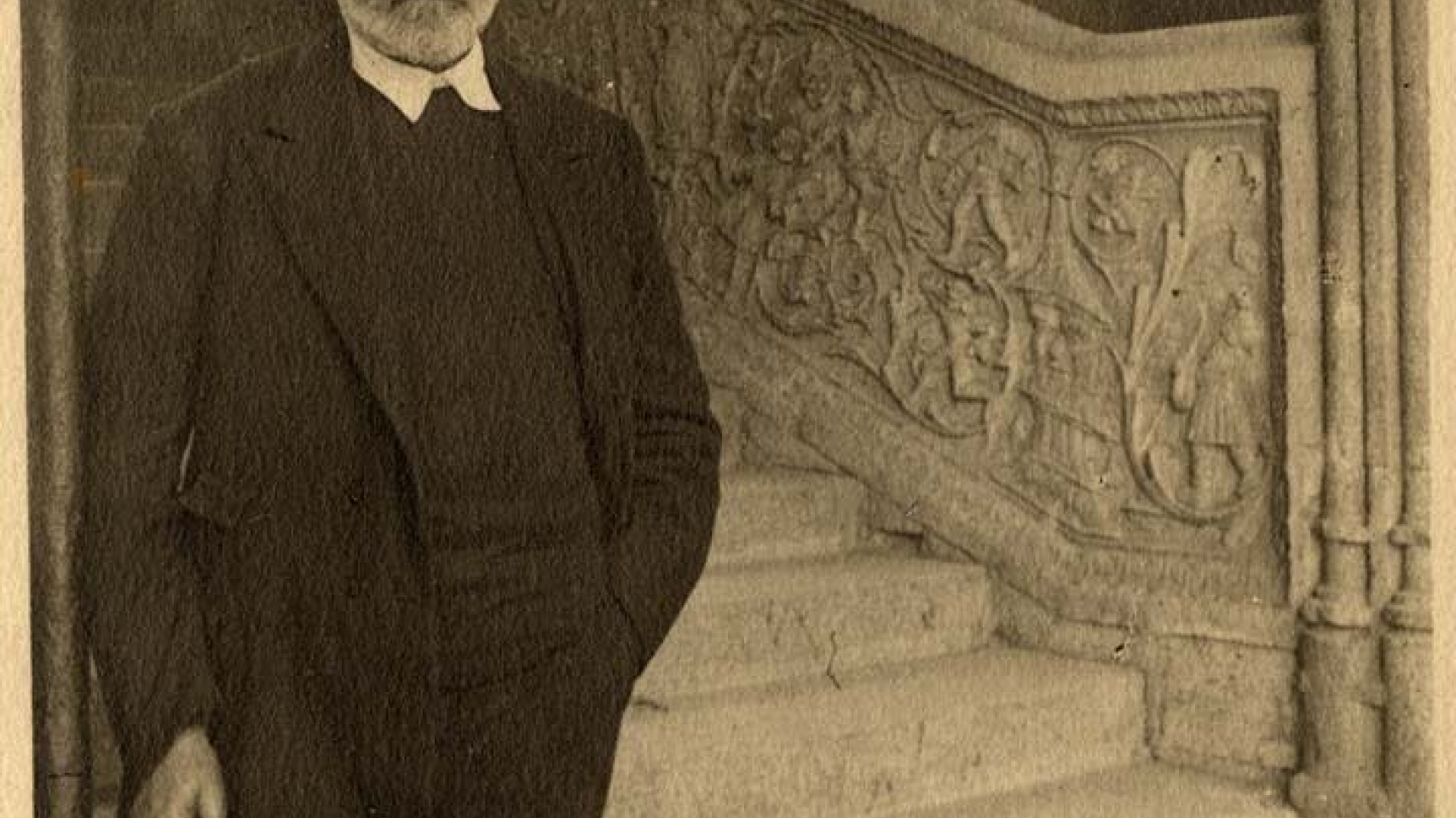 Unamuno junto a la escalera renacentista de la Universidad de Salamanca.