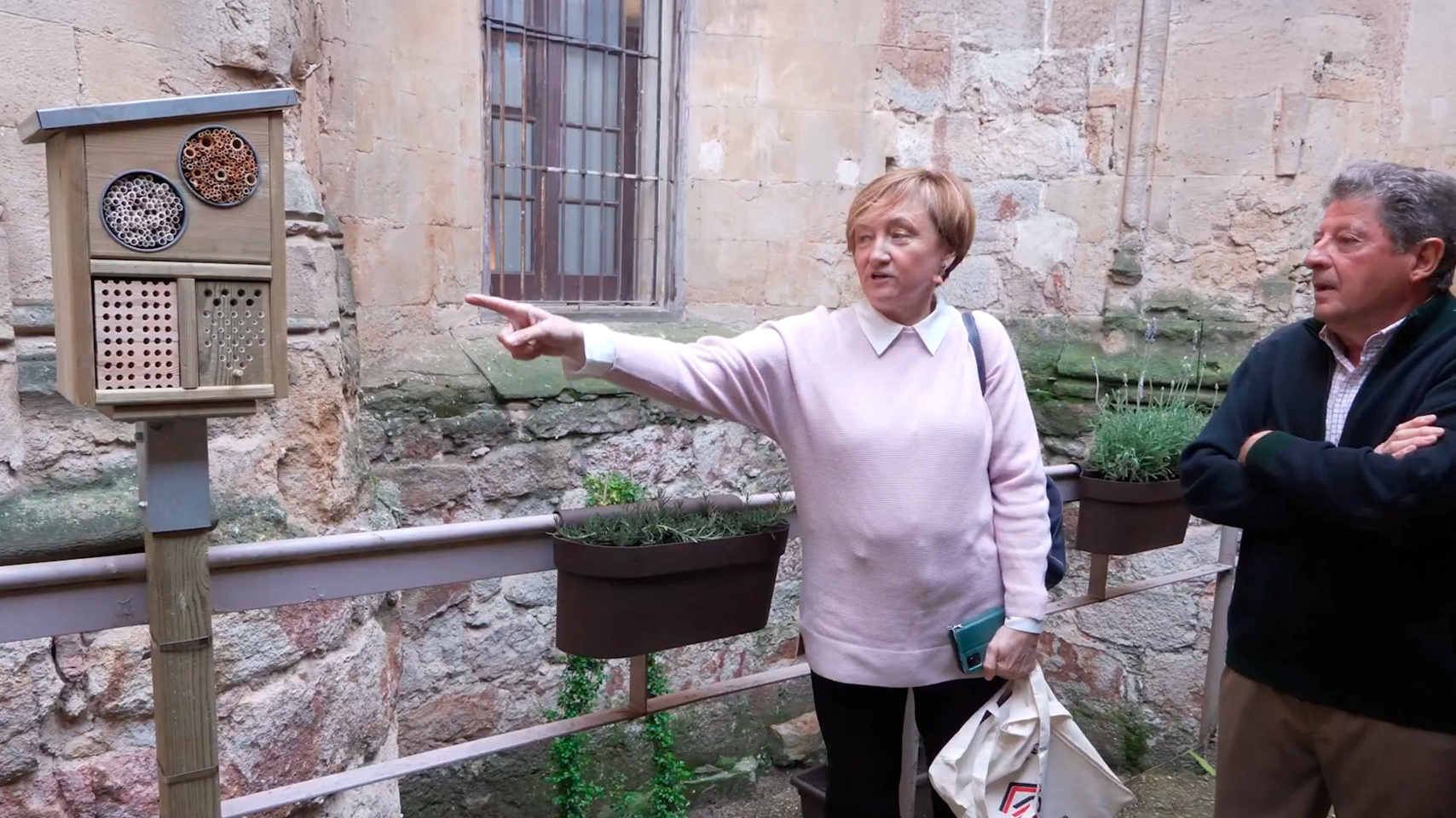 Ana Chaguaceda junto al nieto de Pablo Unamuno enseñándole el refugio de  polinizadores decorado con una silueta de Unamuno realizada por Manuel Álvarez-Monteserín